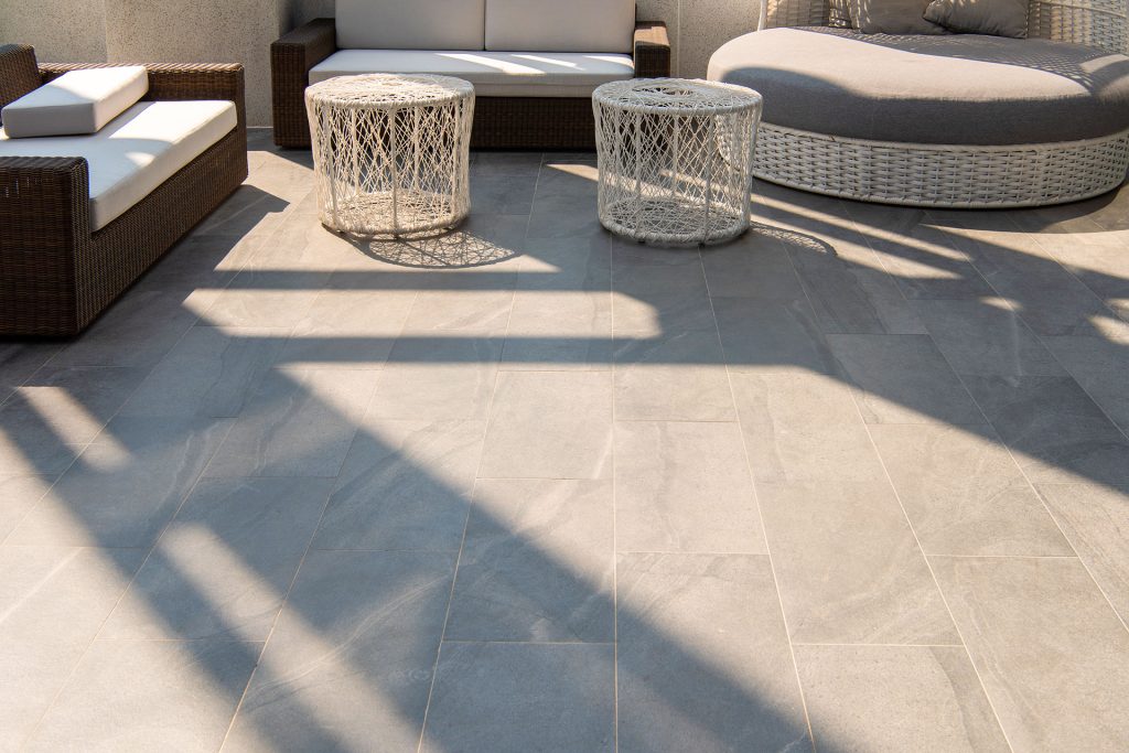 Modern outdoor patio with large format tile and wicker furniture